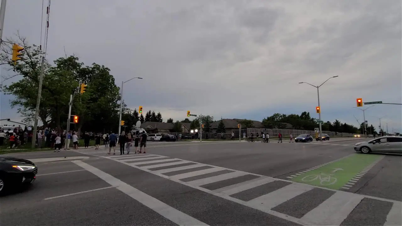 Groups of people cross the street for the tribute to the victims of a terror attack by a terrorist in London Ontario