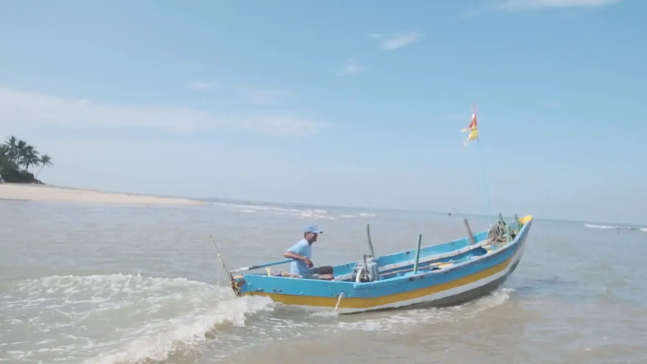 bright blue and yellow Indian fishing boat going out to sea slow motion