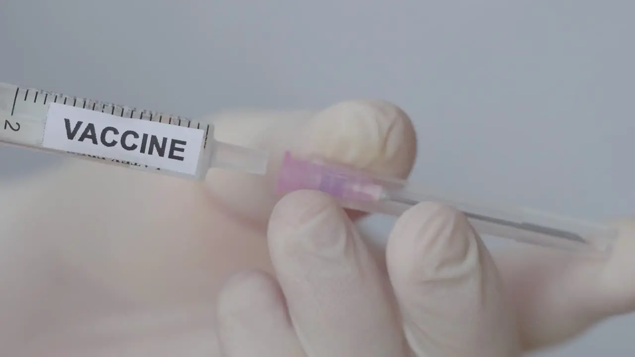 Hand Wearing Glove Attaching Needle On Medical Injection With Vaccine Close Up Shot