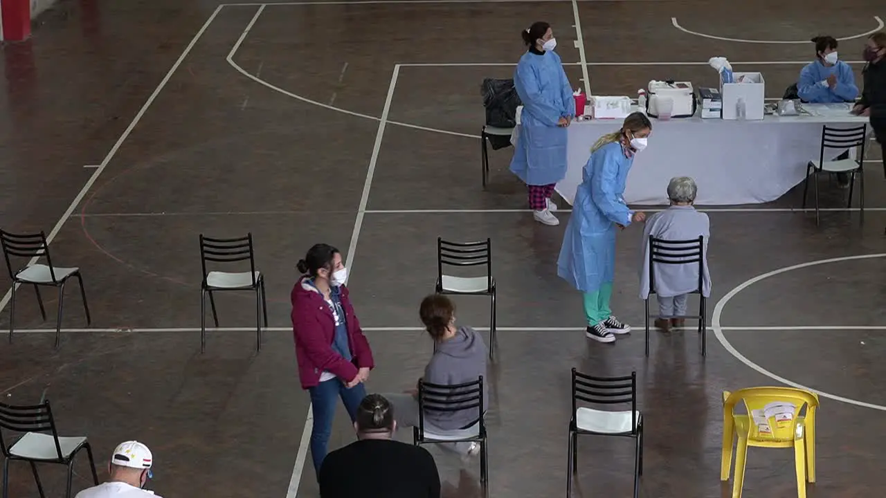 High angle view of healthcare workers applying COVID-19 vaccine inside a makeshift vaccination center