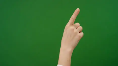 Female finger making swiping gestures on green screen