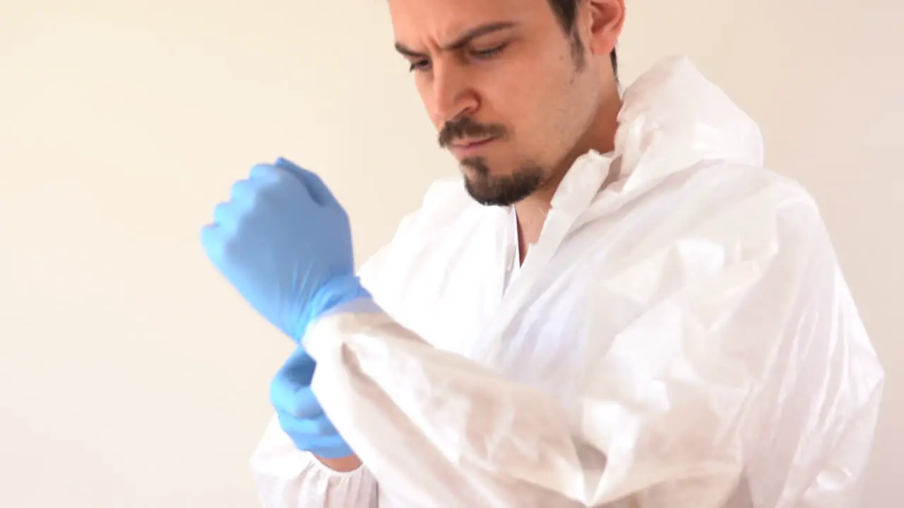 Doctor in PPE suit isolating gloves and suit to start his service