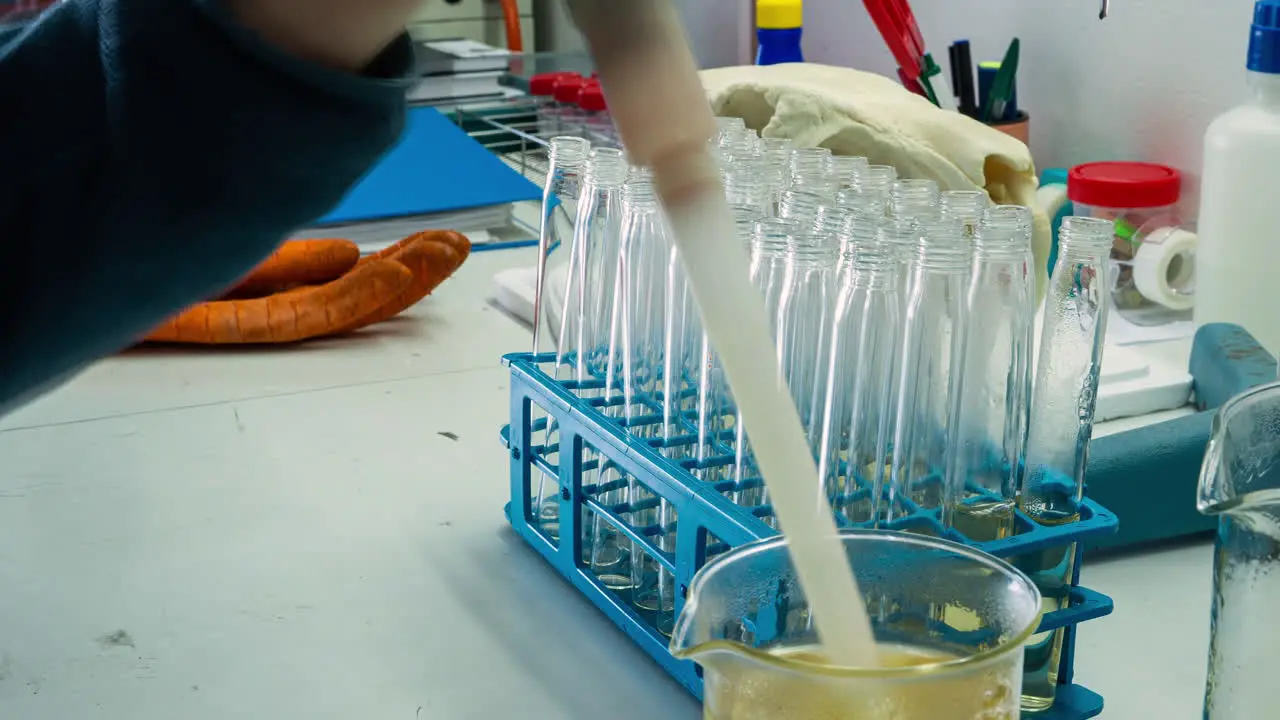 Time lapse of laboratory technician filling vials with a yellow solution