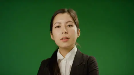 Businesswoman crossing arms on green screen