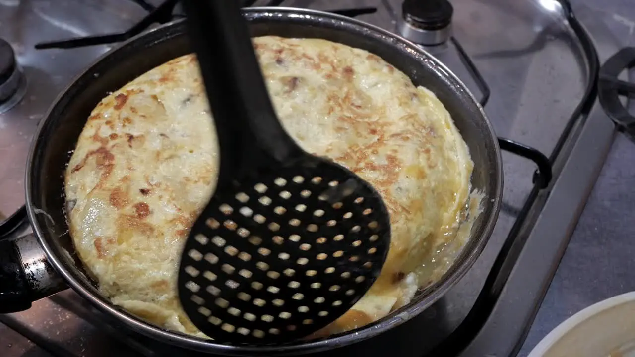 Spanish omelette tortilla cooking in pan