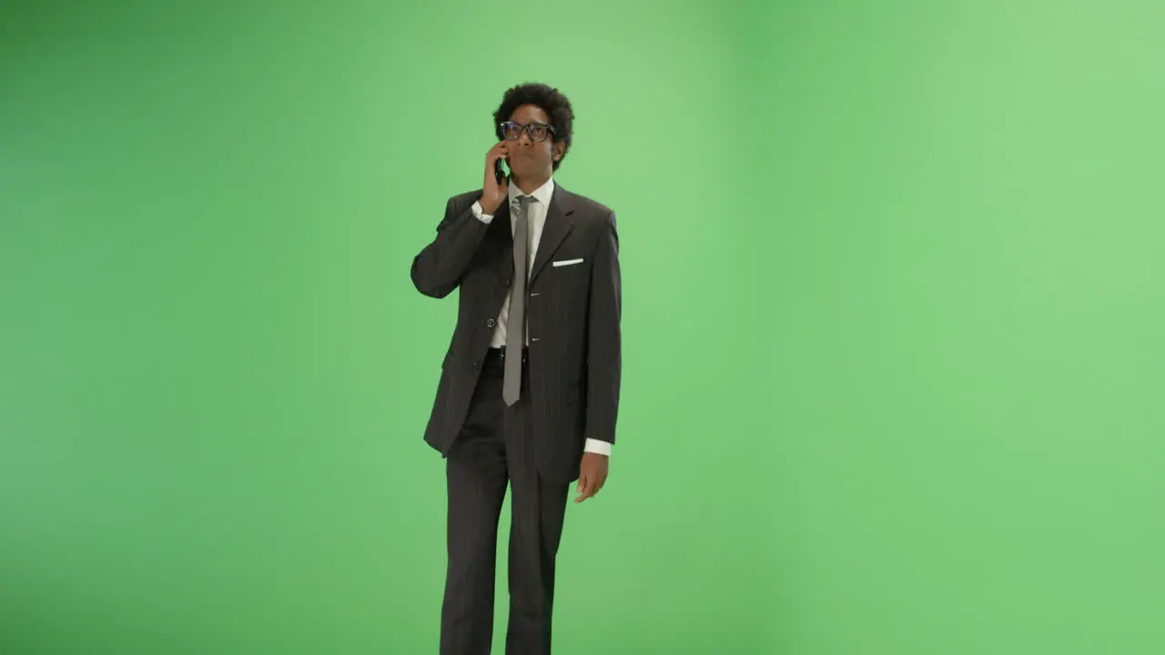 Man in suit talking on phone with green screen