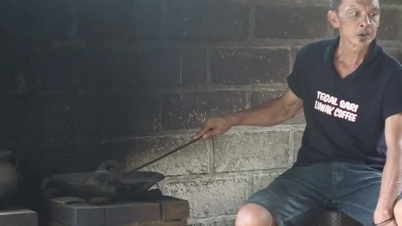 Close up shot of an old man roasting coffee beans in a traditional coffee processing industry in Bali