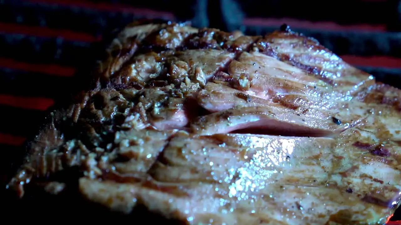 Fresh salmon steak cooking on a hot grill at night