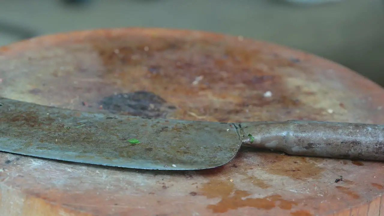 Some people's footsteps can be seen at the back side of the frame behind the chopping with a butcher's knife on top of it in a restaurant in Bangkok Thailand