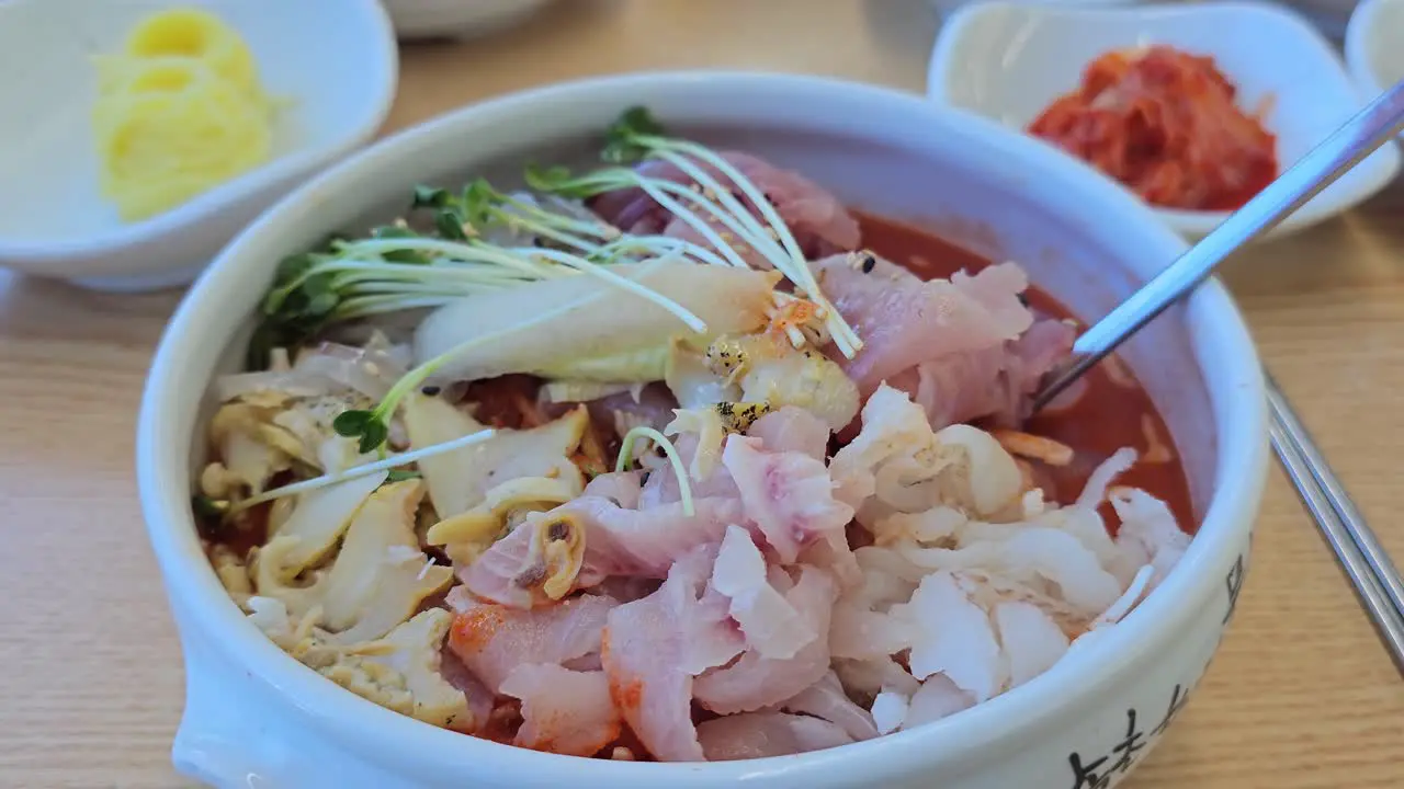 Bowl Of Delicious Mulhoe Served With Various Sashimi In A Korean Restaurant