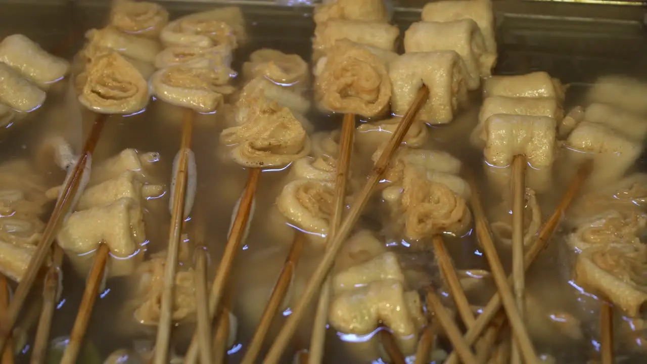 White plain oden on wooden skewers boiling in salty soup