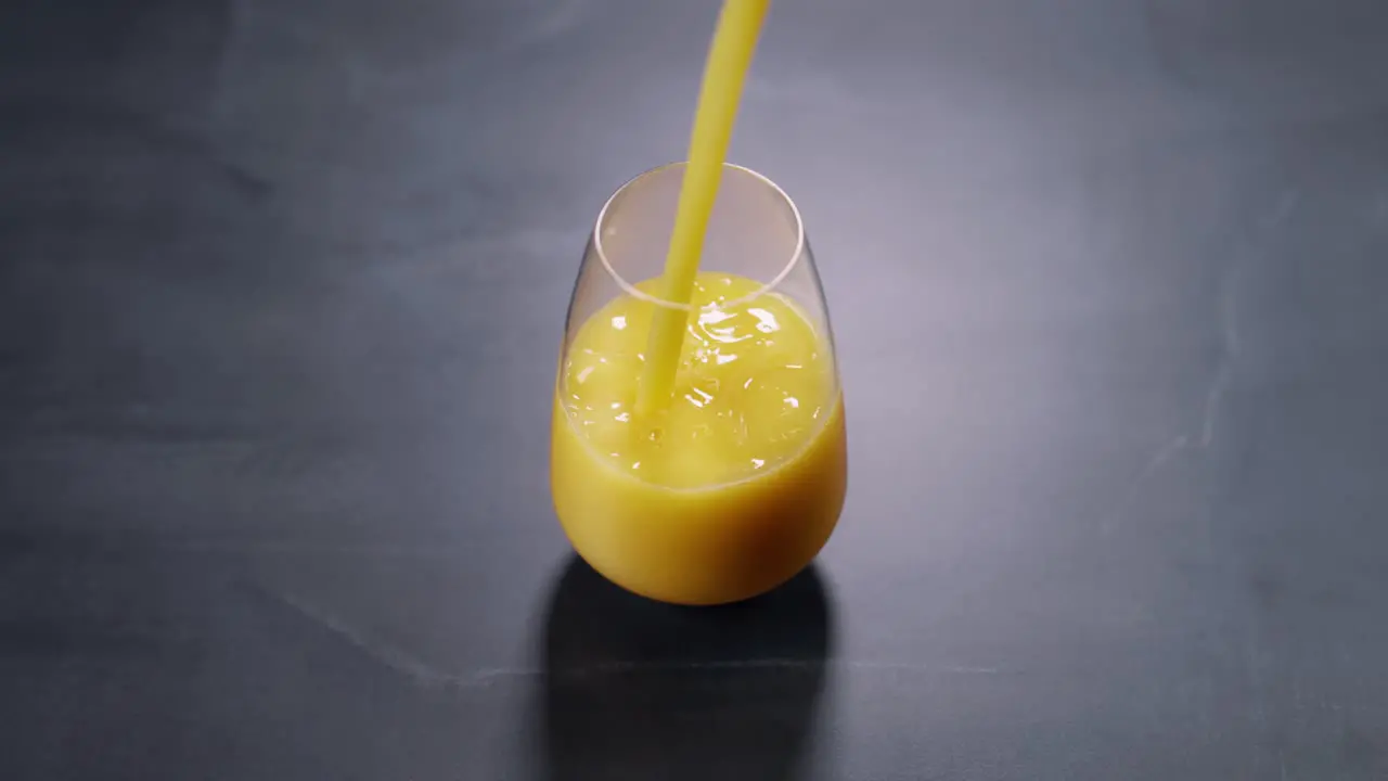 Pouring orange juice into glass in slow mo