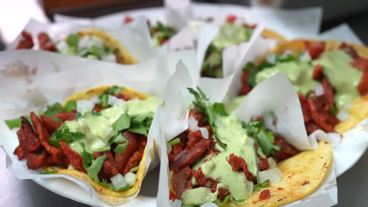 Slow motion savory look at street tacos with guacamole sauce on a plate food truck series