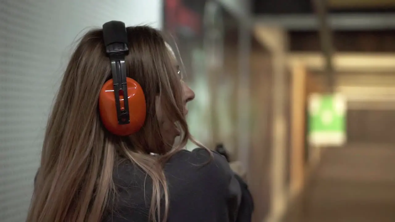 Woman With Pistol Weapon In Hands At Shooting Range With Target Excited And Surprised