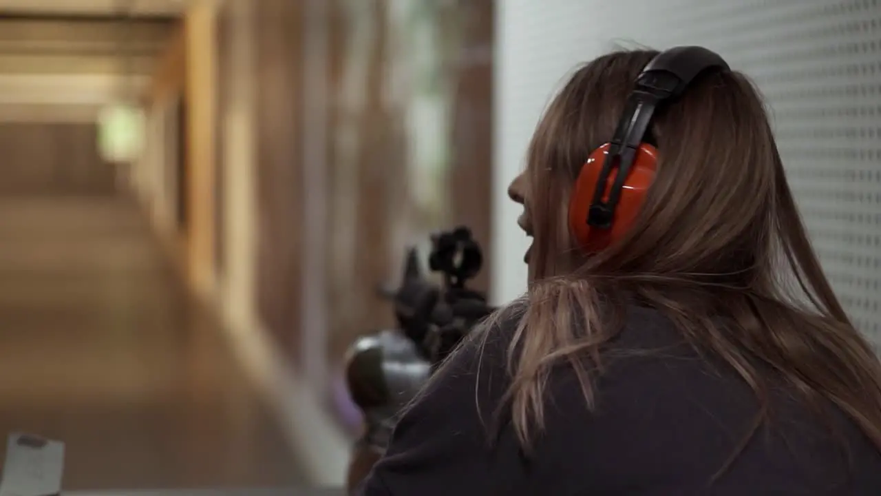 Woman With Rifle In Hands At Shooting Range With Target Excited And Surprised