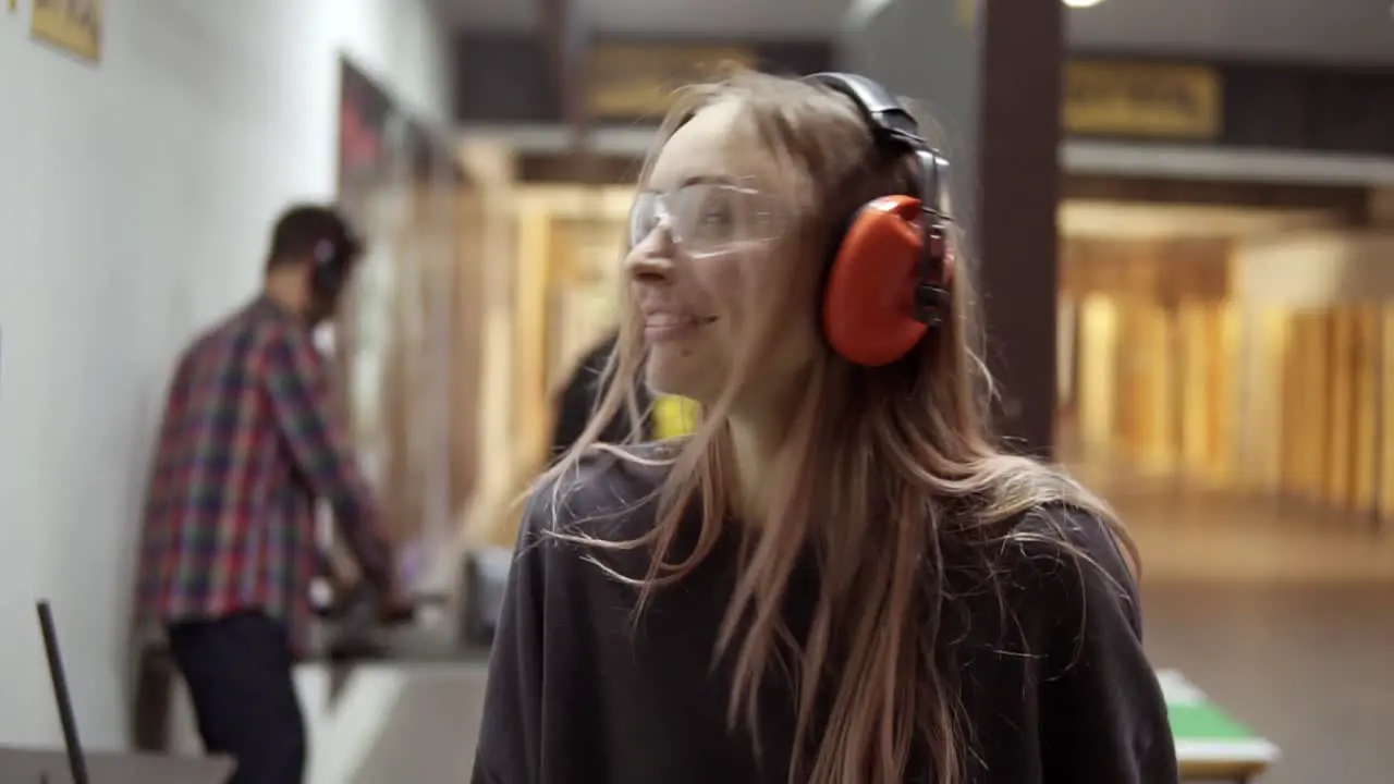 Woman Standing In Shooting Range Surprised By Shot Noise