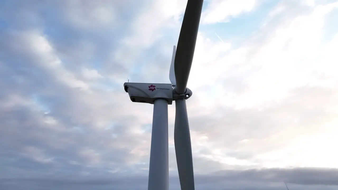 A static wind farm windmill with cloudy pink and blue sky