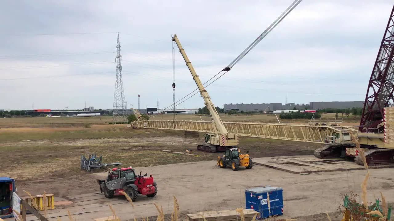 Workers are trying to couple the crane pieces to each other so they can continue to construct the wind turbine