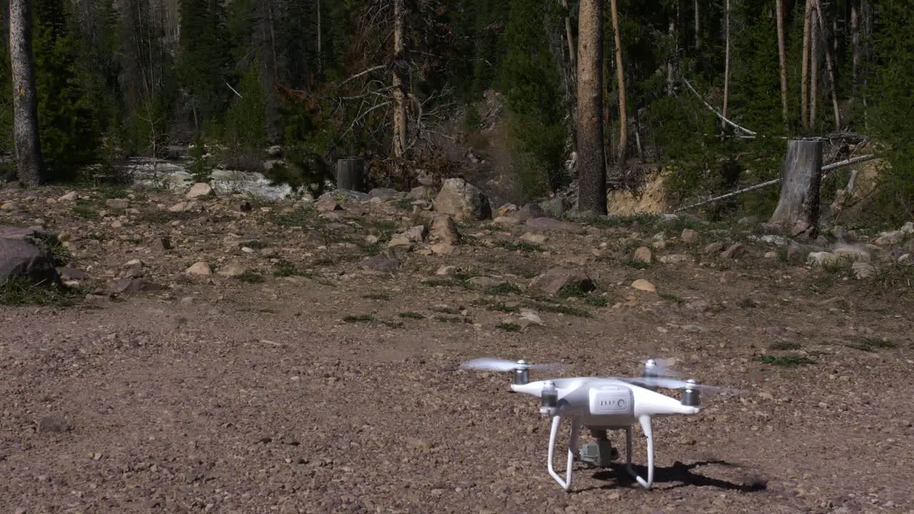 Drone taking off on gravel with river in background