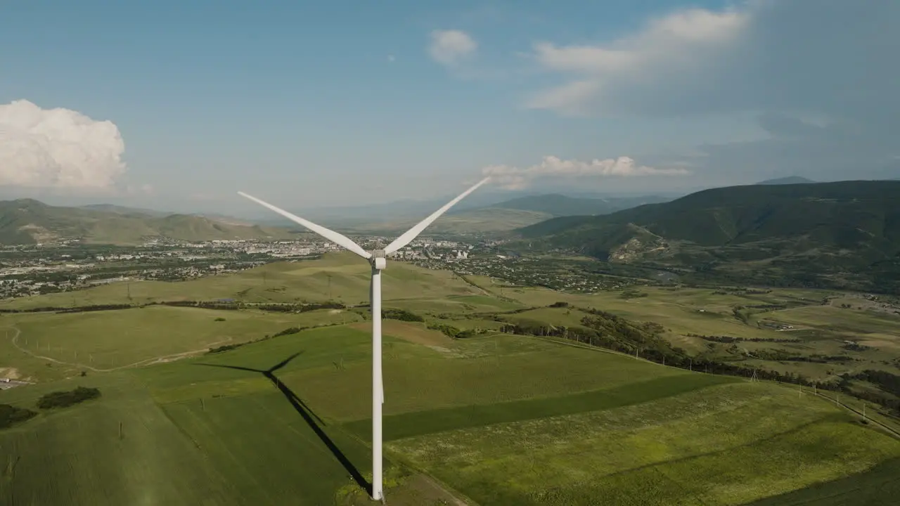 Generator turbine blades rotating in wind above georgian countryside