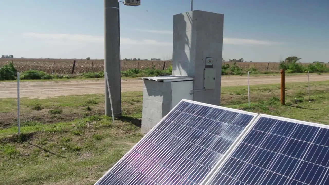 Tilt-up view of solar panels a transformer and a power post in the countryside