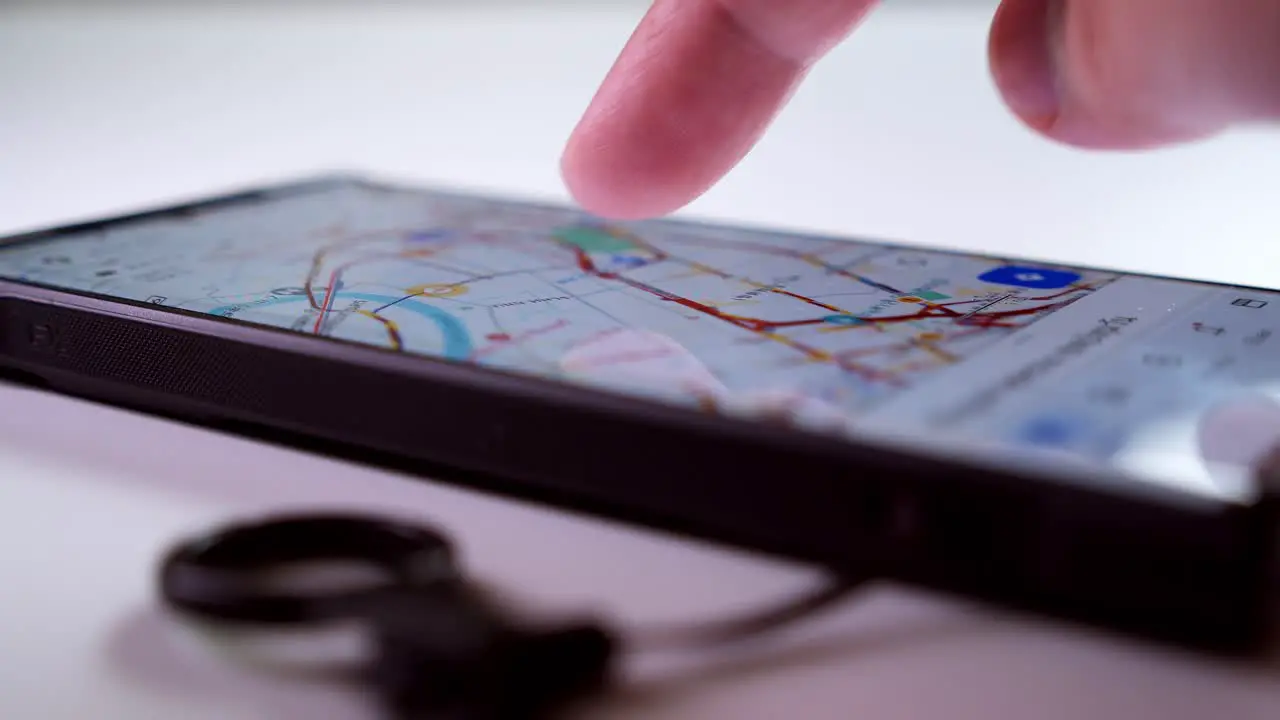 Scrolling the mobile phone to search for the best possible route to a location of a trip using Google Maps