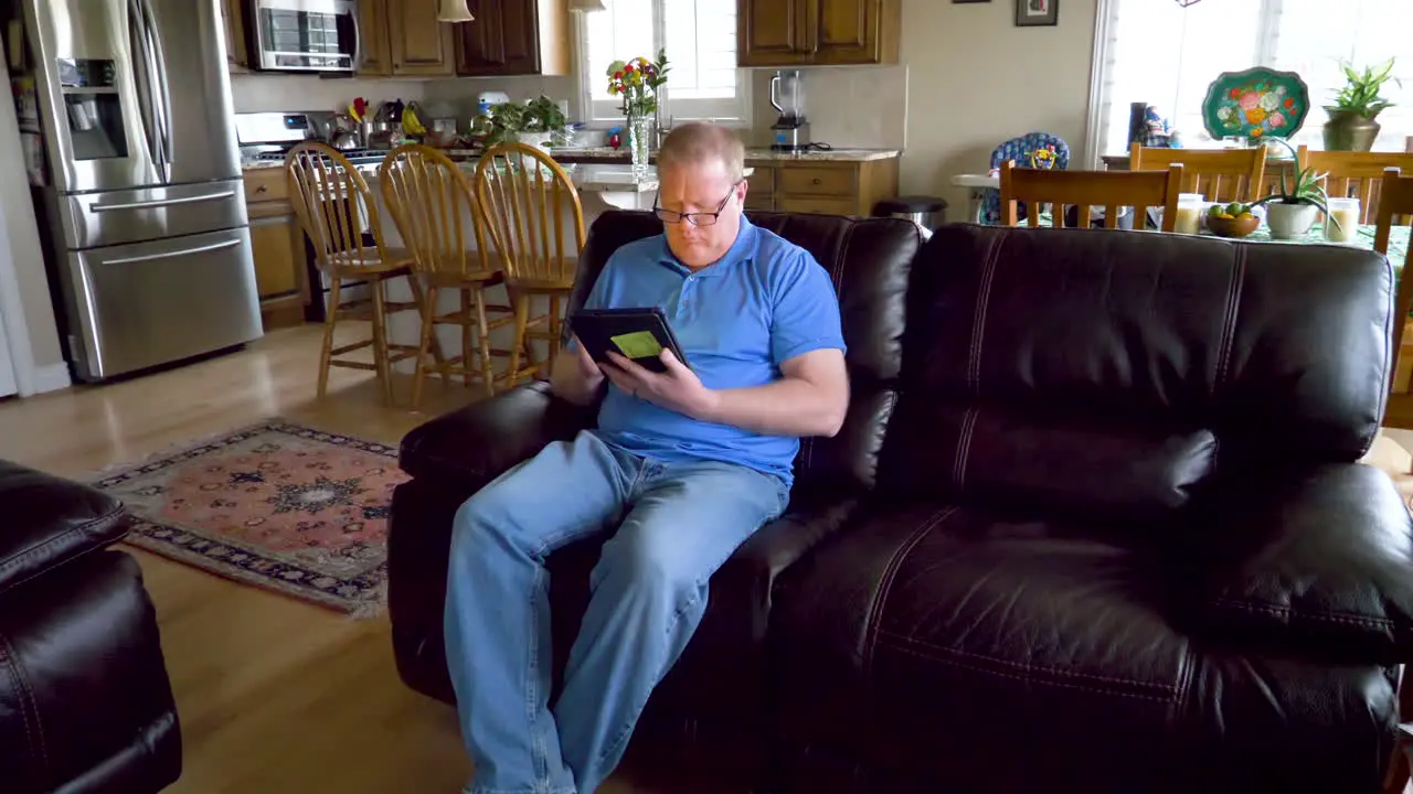 A man uses a tablet to search the internet read shop work or do email