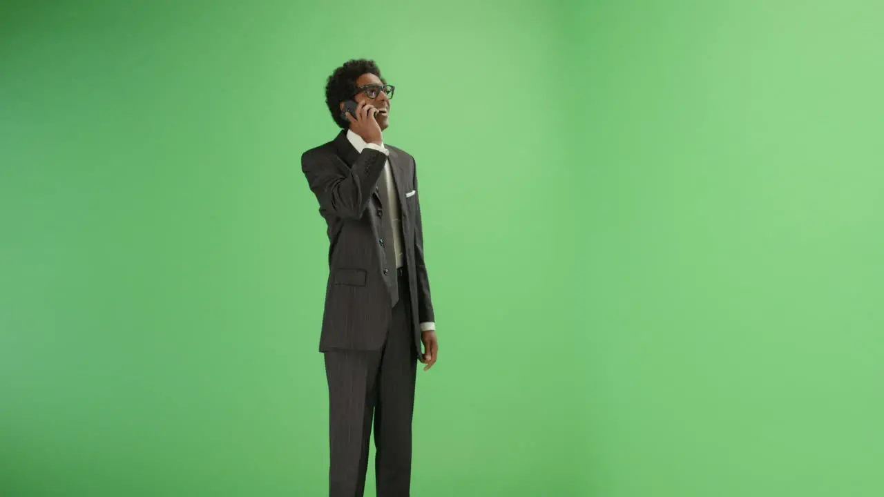 Businessman receives good news on phone with green screen