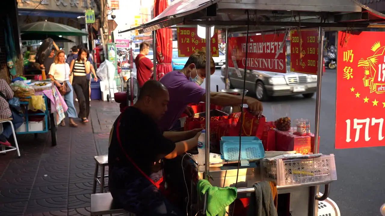 Vendors pack and display Chestnuts prepare for business and await customers at the famous Yaowarat Chinatown Bangkok Thailand