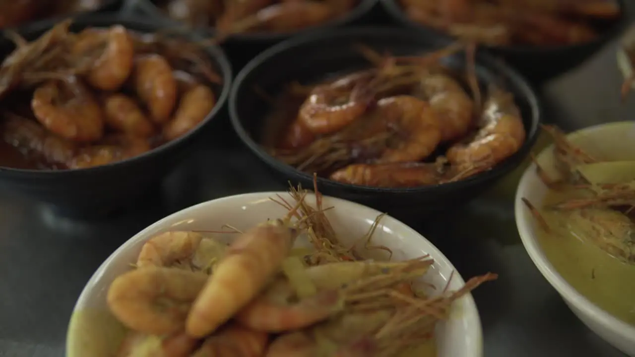 Small cups filled with shrimp with different sauces