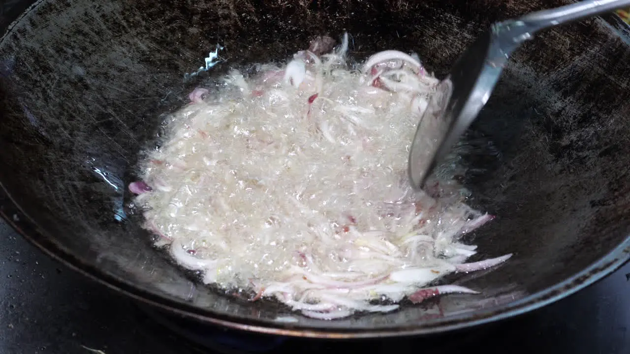 Close up shot Spatula stir Frying chopped red onion in pan Food preparation