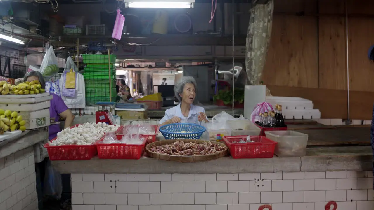 Taiwanese market atmosphere female sitting eating assorted Thai fast food with boxes retail foods