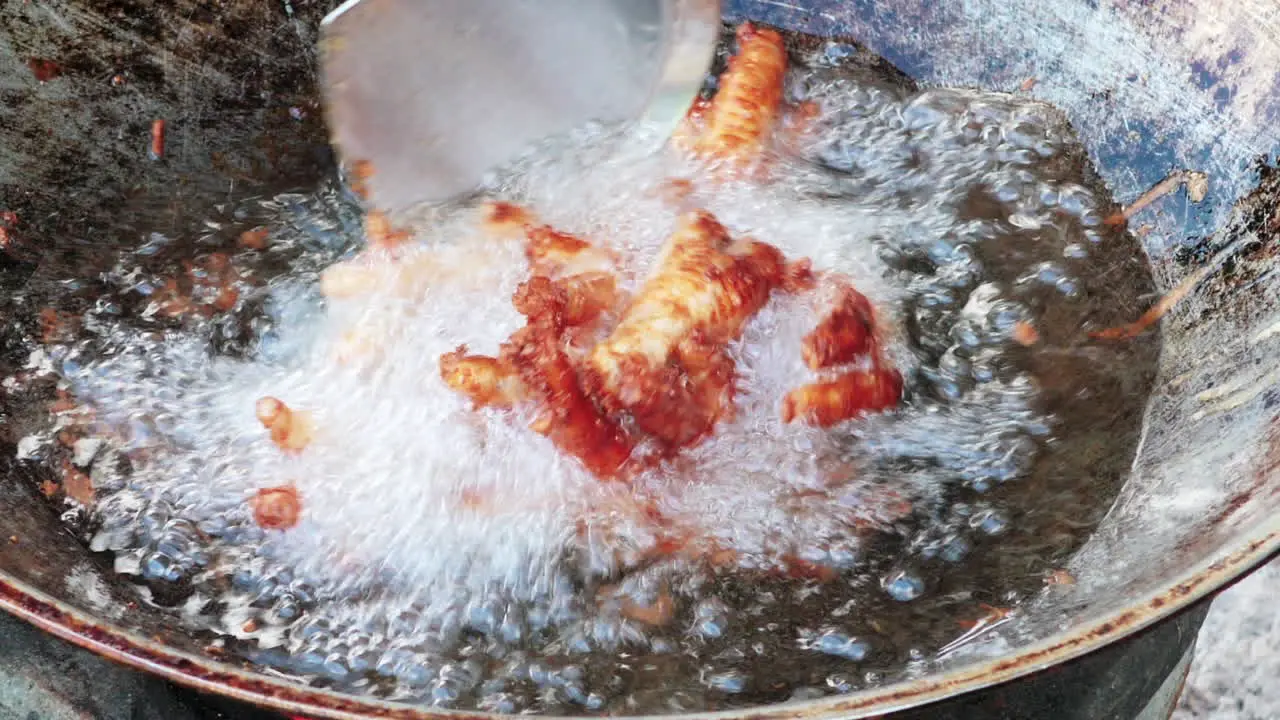 Extreme close up of deep fried chicken feet on hot oil Thailand dish