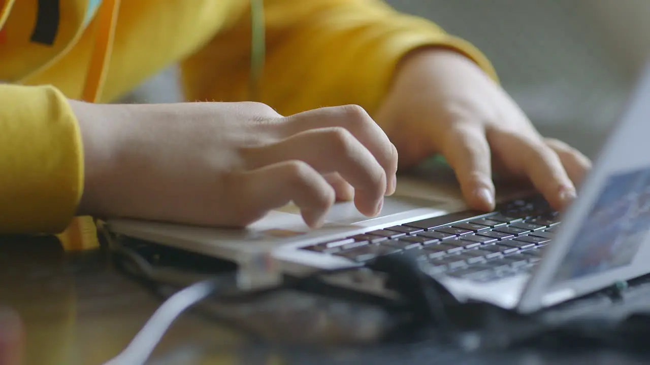 Close up of a boy's hands on a laptop keyboard