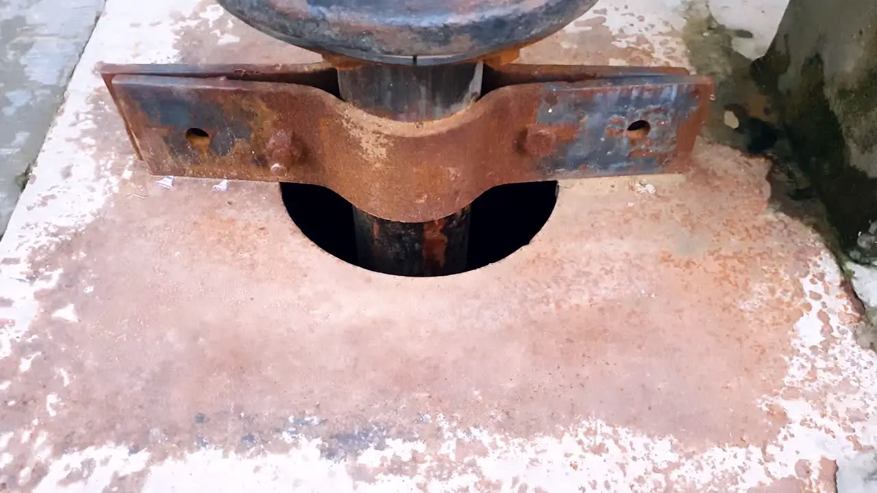 Close up view of ground water extraction from well through metal pipe connected to suction motor