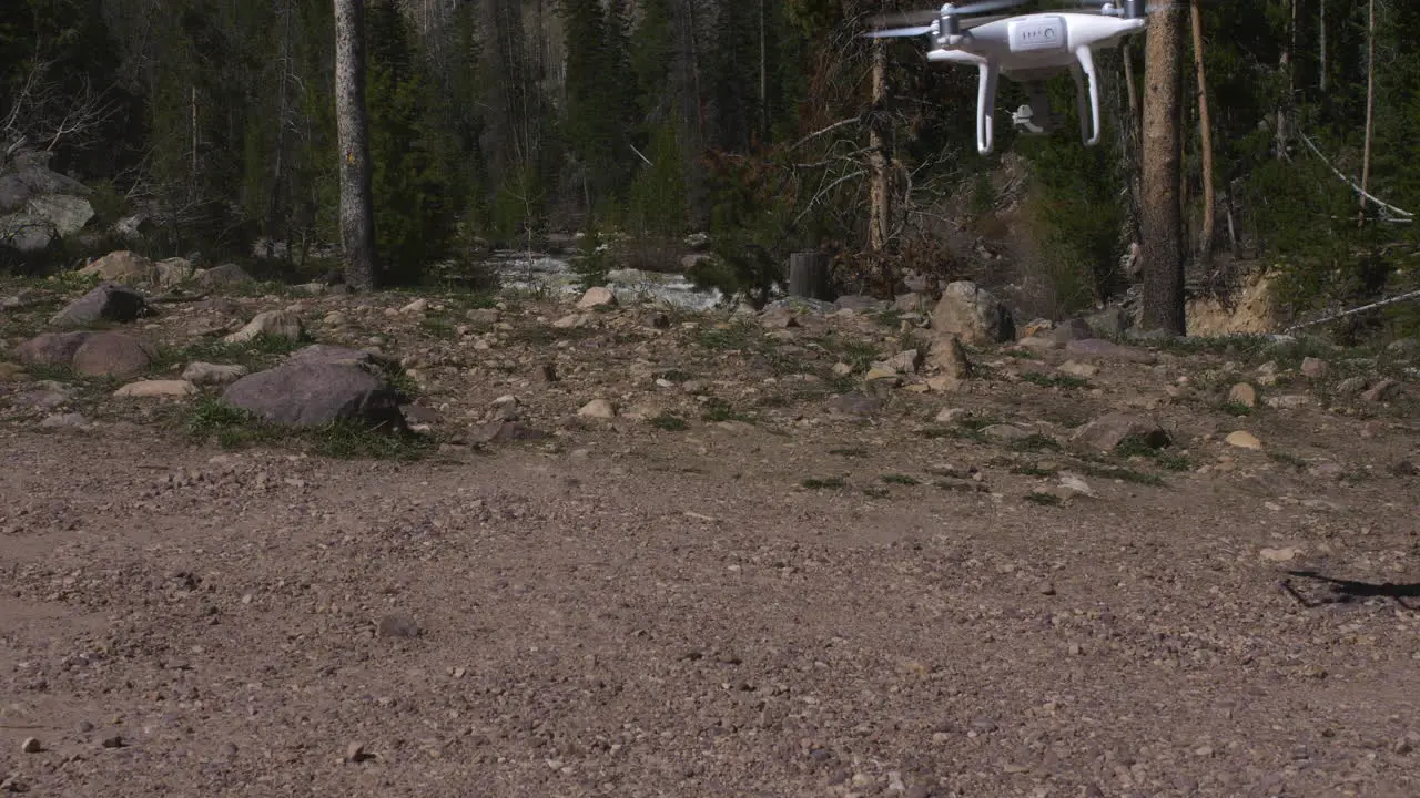 Drone landing on gravel with river in background