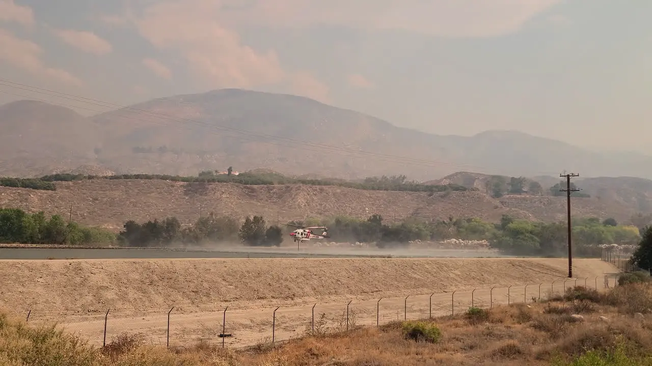 Firefighting helicopter taking off by the water