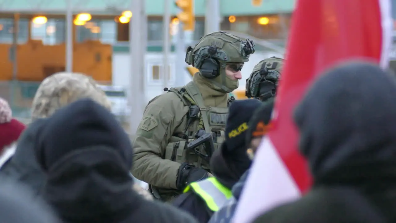 Armed rifle weapon police officer standing guard at scene of protest