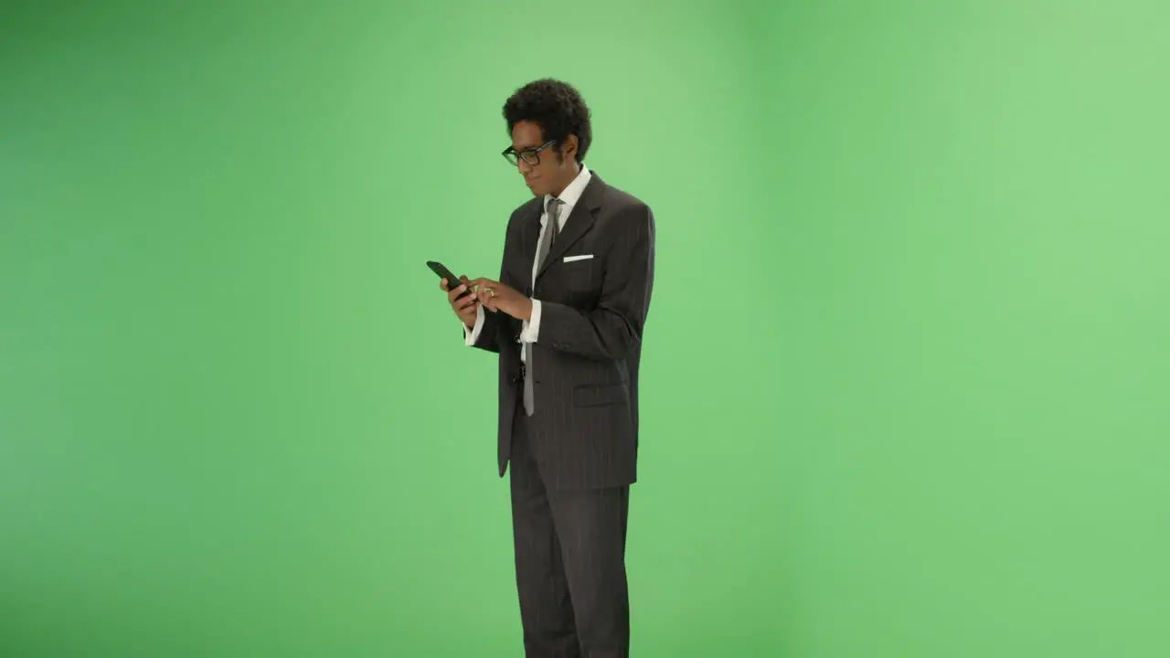 Businessman takes out phone and texts on green screen