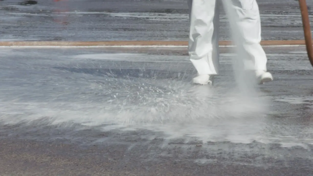 Brazilian soldier in protective gear hosing down the road outside of a hospital telephoto shot of legs