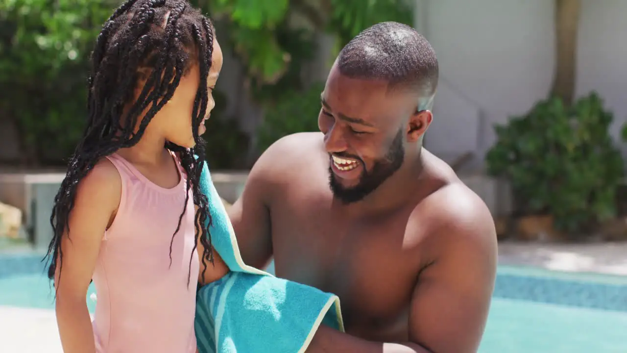 Happy african american father wiping daughter with towel