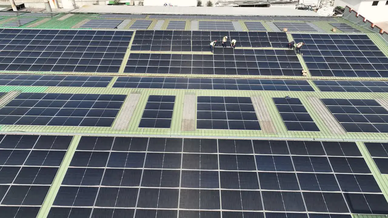 Workers on factory roof installing solar panels