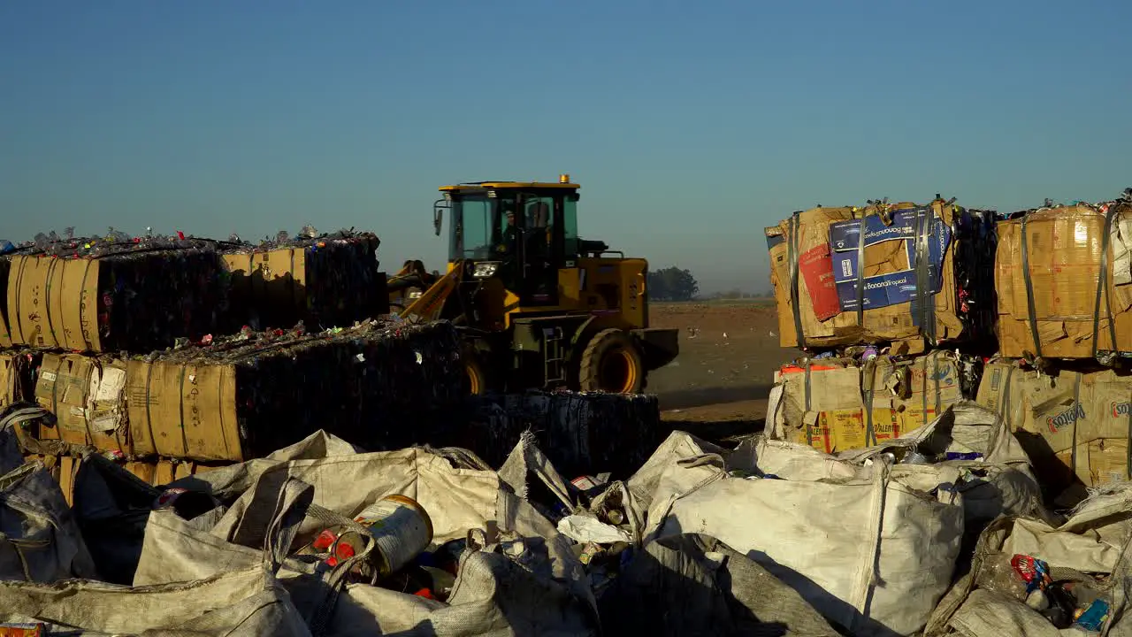 A bulldozer passes by compacted waste in the field of a waste processing plant