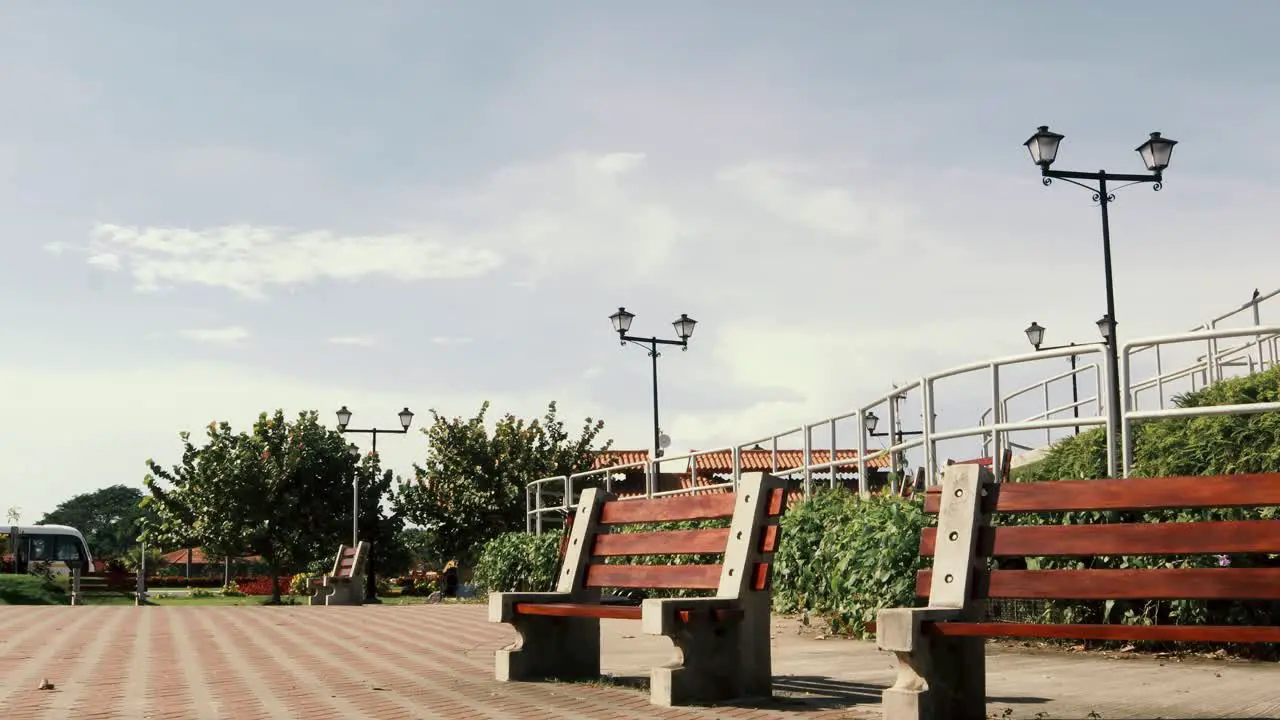 Timelapse of public park with beautiful vegetation street lamps benches and a clear blue sky during a hot sunny morning at Panama CIty's Causeway of Amador