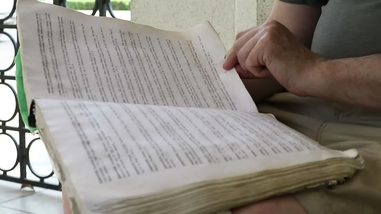 HD Static Shot of World War Two Memorial Graveyard with Person Reading a Book about Prisoners of War in a Peaceful Cemetery in Kanchanaburi Thailand