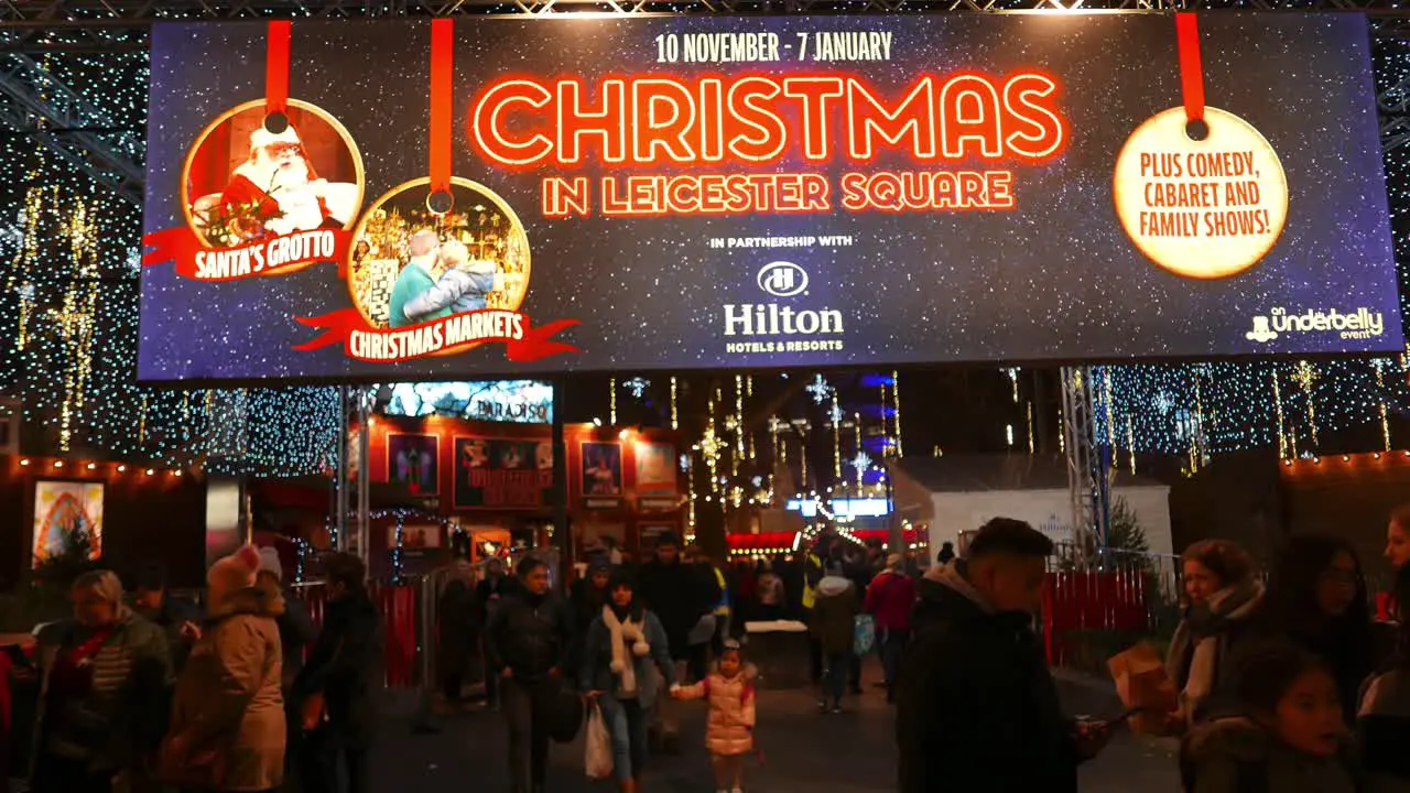 People moving in and out of the Christmas market at Leicester Square in London UK