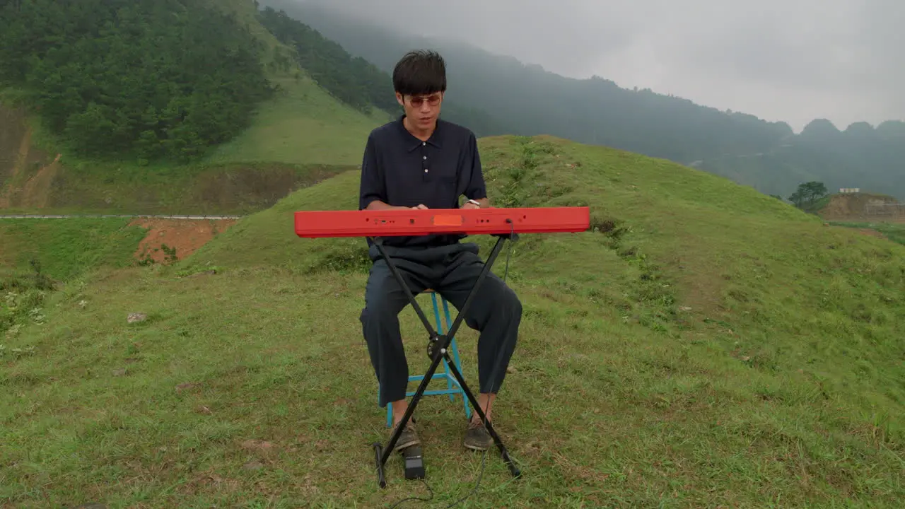 Keyboard player sitting down playing instrument Picturesque landscape