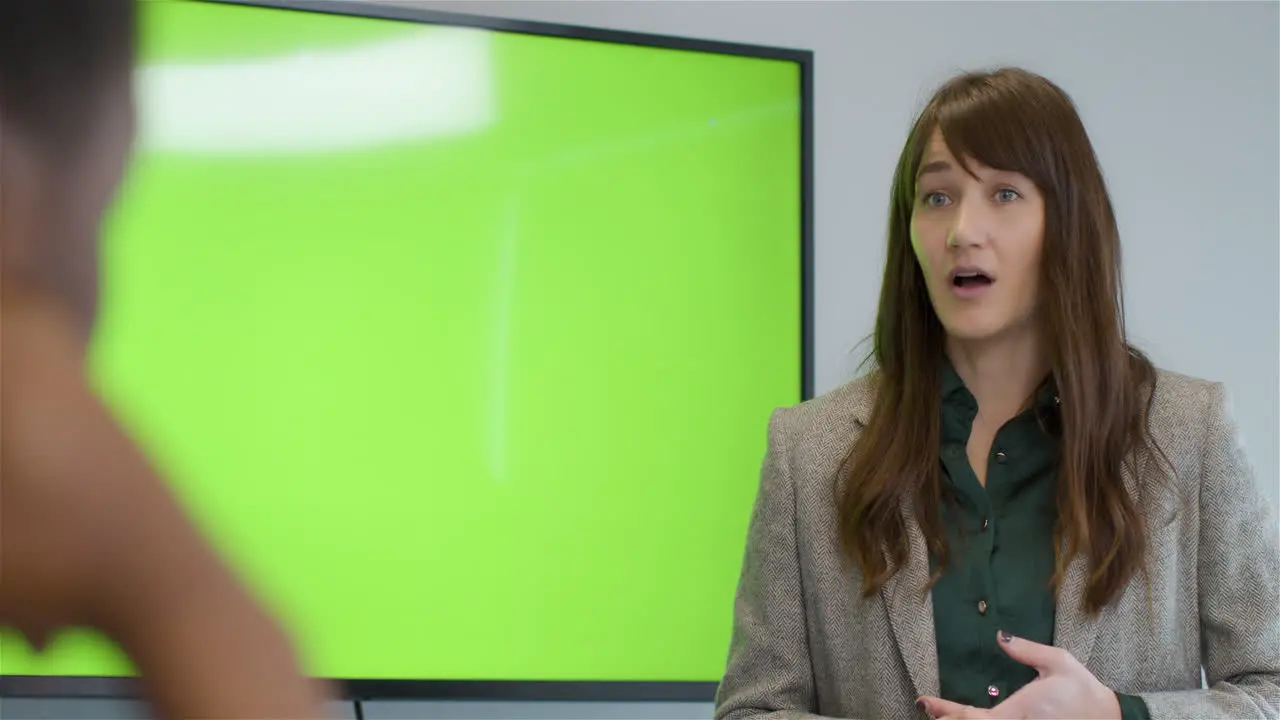 Businesswoman Talking To Colleagues With Green Screen Tv