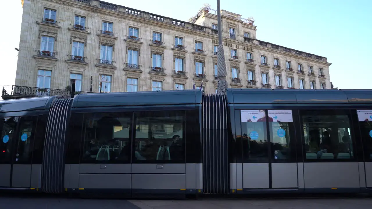 Tramway car passes in front of the Intercontinental Hotel with people walking along Handheld shot