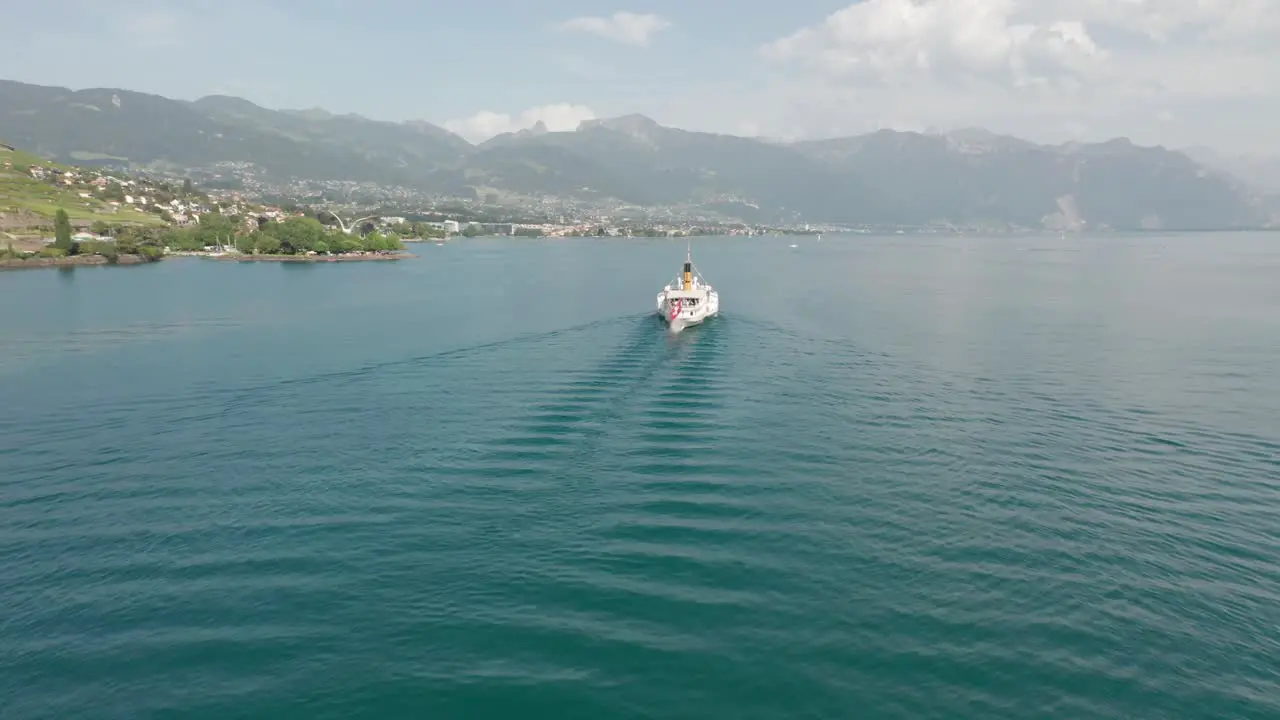 Drone flying away from classic cruise ship on Lake Geneva on a summer day